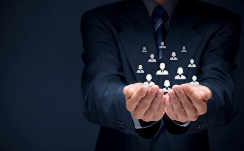 Businessman holding icons representing teamwork and collaboration.